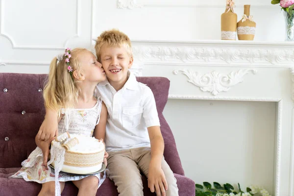 Niedlichen Kleinen Jungen Und Schönen Mädchen Sitzen Auf Einem Stuhl — Stockfoto