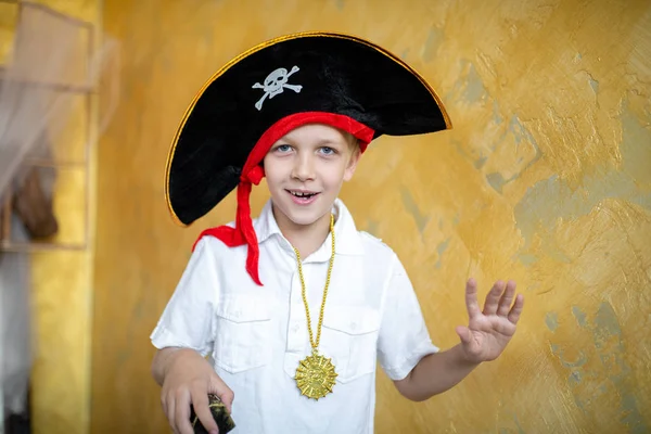 Boy pirate preparing for the holiday Halloween. Big pirate hat captain of a ship, male role play at a costume party children\'s holiday. Fun and emotions for a good mood. Studio wall horizontal banner