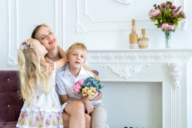 Güzel kadın kanepede onun oğlu ve kızı ile oturuyor. Annem çocukları seviyor. Aile kavramsal afiş, aşk bakım hassasiyet. İyi ki doğdun parti pozitif yaşam tarzı. Profesyonel fotoğraf