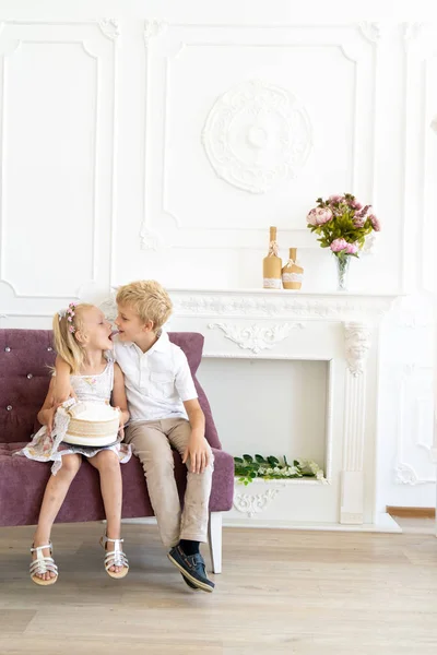 Niedlichen Kleinen Jungen Und Schönen Mädchen Sitzen Auf Einem Stuhl — Stockfoto