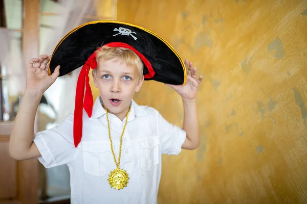 Boy pirate preparing for the holiday Halloween. Big pirate hat captain of a ship, male role play at a costume party children\'s holiday. Fun and emotions for a good mood. Studio wall horizontal banner