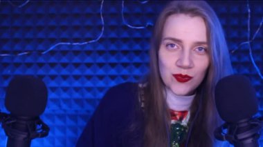 Asmr Video - zihin gevşemesi için binaural sesler, karıncalanma, zevk. Mavi ceketgenç güzel kadın, yüz duyguları, kırmızı dudaklar gülümsüyor, merak ediyor, bir tarak gibi onu uzun güzellik saç dolar tutar