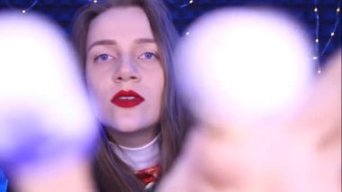 ASMR video-Binaural zihin, karıncalar, zevk gevşeme için sesler. Genç güzel kadın izleyiciye yüz masajı yapar. Yüz dokunuşlu, Görsel Tetikleyiciler. Kırmızı dudaklar mavi gözler, mükemmel gülümseme beyaz dişler