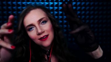 Genç gülümseyen kadın ASMR sesleri çıkarıyor. Rahatlatıcı eldivenler ve el sesi. Derin rahatlama için en iyi tetikleyici siyah eldivendir. İzleyicinin yüzüne dokunan eller, masaj. Kulaktan kulağa fısıldayarak.