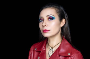 Profesyonel makyajlı güzel bir kızın portresi, geniş siyah oklar, düz saç stili, esmer. Lüks makyaj, parlak ruj, parlak kozmetik ürünler, günlük tarz, koyu kırmızı deri ceket.