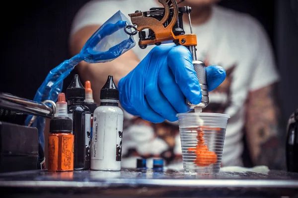 Hand of a tattooer, holding a tattoo device. — Stock Photo, Image