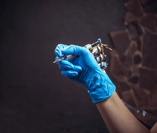 Hand of professional tattooist with a tattoo machine. — Stock Photo, Image
