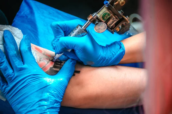 Professional tattoo artist makes a tattoo on the clients tattoo studio — Stock Photo, Image