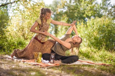 Kız masöz bir orman temizleme ferahlatıcı masaj yöntemleri gösterir.