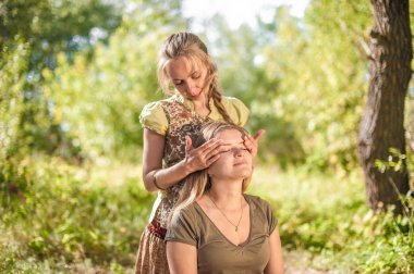 Masaj uzmanı güneş ışığında ferahlatıcı masaj yöntemleri gösteriyor.