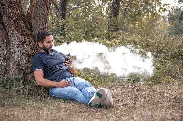 Uomo fumare una sigaretta elettronica all'aperto — Foto Stock