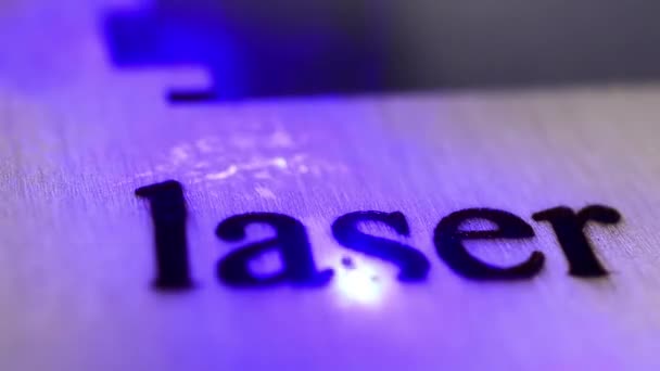 Productie Laser brandt het woord laser in het werkstuk. Close-up. — Stockvideo