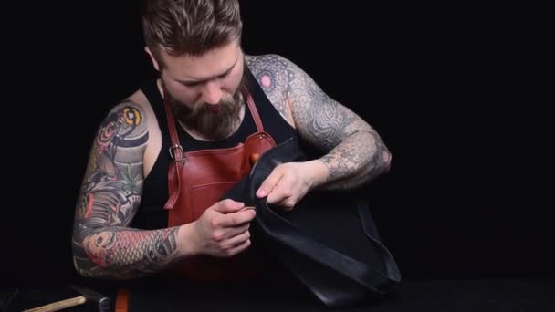 Профессиональный портной делает новый продукт кожи в мастерской — стоковое видео