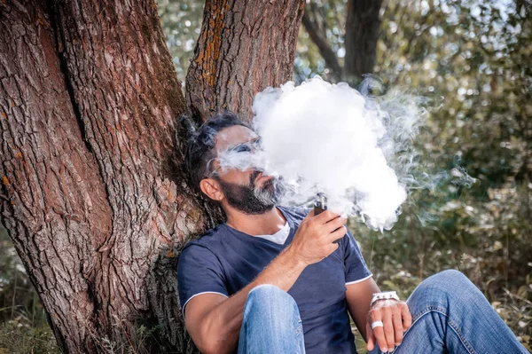 Il vaper brutale rilascia una nuvola di vapore. Sigaretta ibrida . — Foto Stock