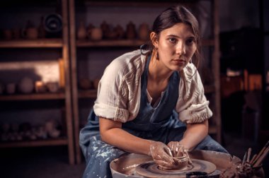 Charming çömlek ustası kil ve çanak çömlek tekerleği ile nasıl çalışılı olduğunu gösterir. El sanatları üretimi.