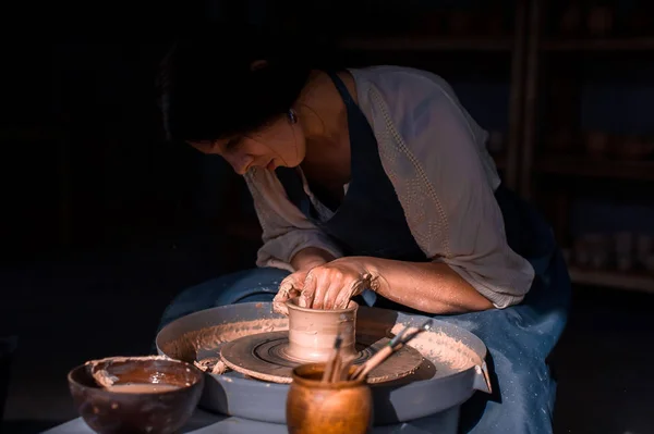 Elegante maestro artesano haciendo cerámica, escultor de arcilla mojada en la rueda. Producción artesanal . — Foto de Stock