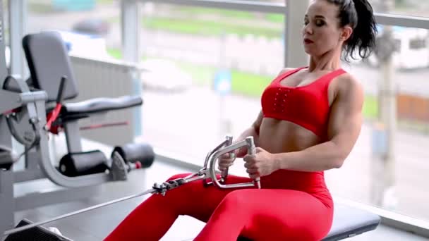Αθλητική γυναίκα γυμναστήριο κάνει ασκήσεις για την πλάτη και ποζάρει στο γυμναστήριο — Αρχείο Βίντεο