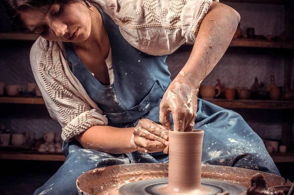 Charming ceramist woman shows how to work with clay and pottery wheel. Making ceramic dishes. — Stock Photo, Image