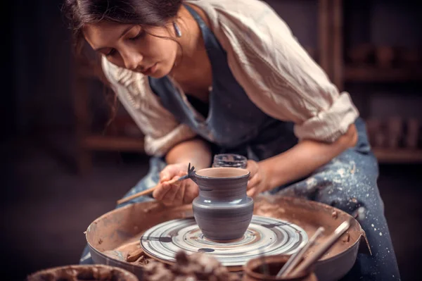 Charming female master sculpts from clay. The concept of craft creativity.