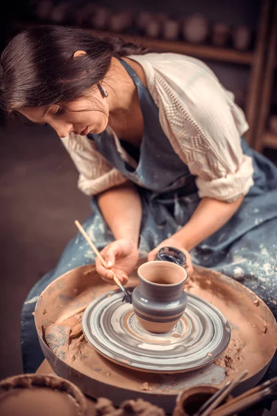 Affascinante giovane e allegra donna dimostra il processo di fabbricazione di piatti in ceramica utilizzando la vecchia tecnologia. Prodotti fatti a mano . — Foto Stock