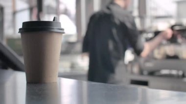 Barda bir bardak kahve. Bulanık arka plan. Barista kahve dükkanında müşteri için kahve fincan hazırlanıyor.