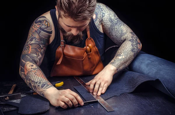 Leather Worker keen on ones business at his leather studio