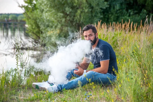 Elegante uomo brutale che usa il vaporizzatore per vaporizzare invece di fumare. Non fumatori di tabacco . — Foto Stock