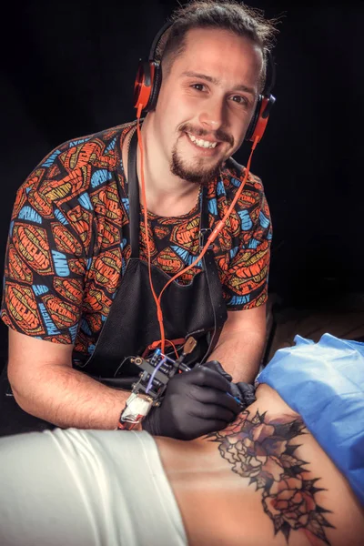 Meester van de kunst van het tatoeëren werken aan professionele tattoo machinegeweer in de salon — Stockfoto