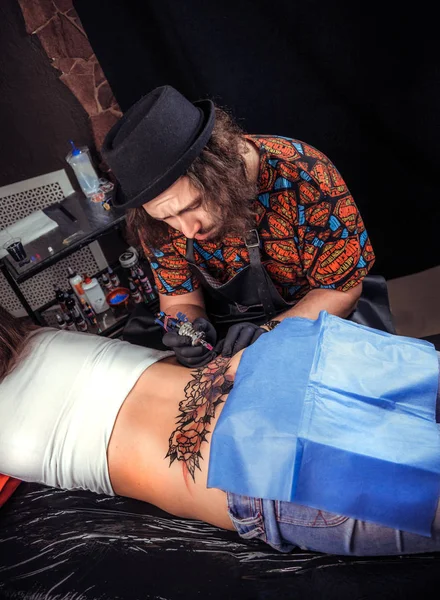 Tattooist tetoválás a bőr, az ő ügyfele a tetováló szalon — Stock Fotó