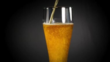 Siyah arka plan üzerinde bir bardak soğuk ışık bira. Zanaat bira yakın. 4k Uhd video