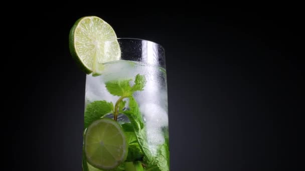 Verse Mojito cocktail met limoen, munt en ijs in potglas op donkere achtergrond. Zomer koud drankje en cocktail — Stockvideo