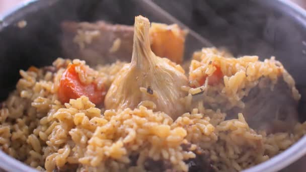 Pilaf con ternera, zanahorias, cebollas, ajo y pimienta. Un plato tradicional de cocina asiática — Vídeo de stock