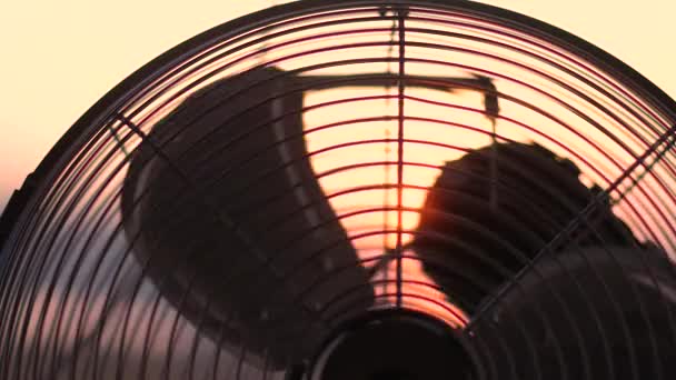 Elektrischer Ventilator vor dem Hintergrund eines klaren Sonnenuntergangs. Konzept — Stockvideo