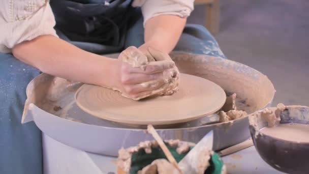 Frau arbeitet an einer Töpferscheibe. Modellierung von Ton. Workshop zum Modellieren auf der Töpferscheibe. — Stockvideo