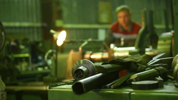 The Turner grinds the part on the lathe at the factory. The Turner in the background is out of focus — Stock Video