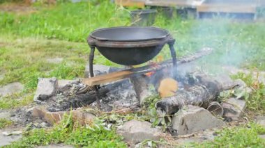 Bifteği pilav yapmak için açık bir odun ateşinin üzerinde kızartıyorlar.