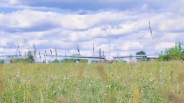Çimlerin üzerinde sessizce dinlen, uçağın arka planı bulanık.