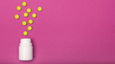 İlaç şişe ve sarı hap parlak pembe renkli arka plan üzerine döktüm. İlaç ve reçeteli ilaç düz arka plan yattı. Opioid salgın.