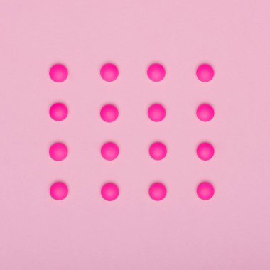 Üst üste pembe pastel renkli arka plan üzerinde izole, parlak pembe haplar. İlaç ve reçeteli ilaç düz yatıyordu arka plan.
