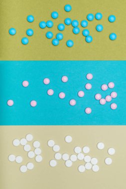 Pastel renkli arka plan üzerinde izole çeşitli renkli hapları ürün yelpazesine. İlaç ve reçeteli ilaç düz yatıyordu arka plan.