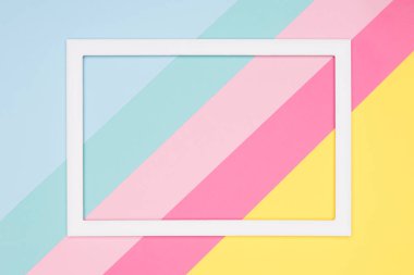 Soyut geometrik pastel mavi, pembe ve sarı kağıt düz yatıyordu arka plan. Boş resim çerçevesini sahte kadar minimalizm, geometri ve simetri şablonuyla.