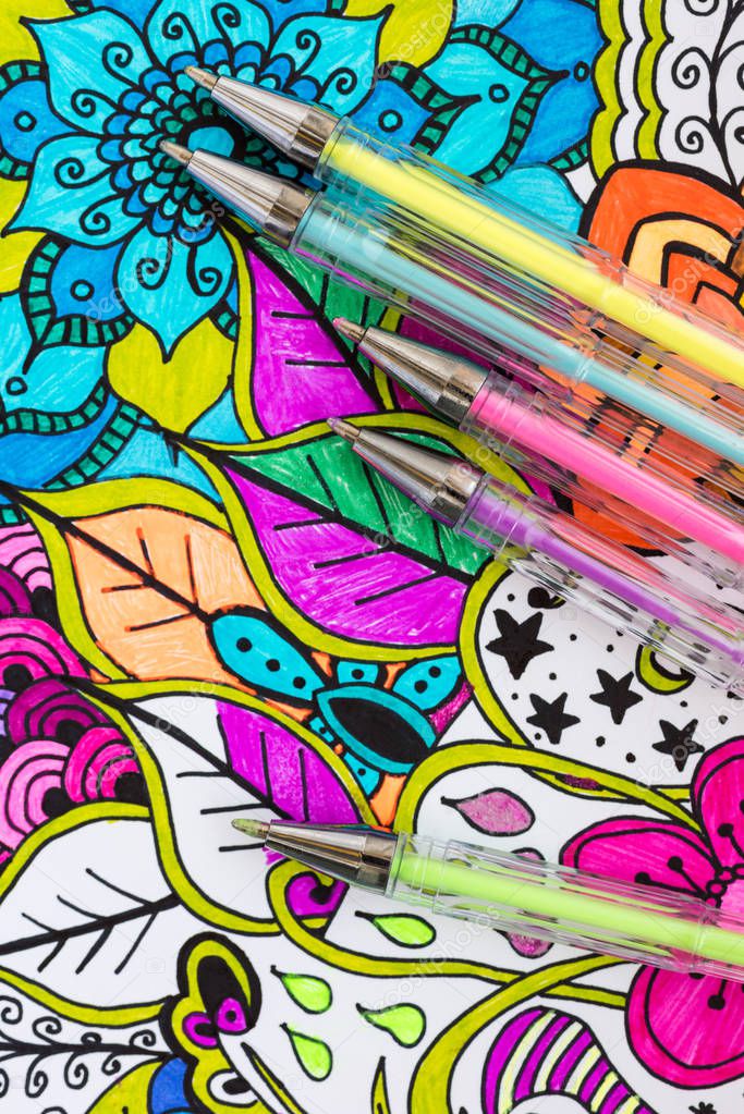 Adult coloring book, new stress relieving trend. Art therapy, mental health, creativity and mindfulness concept. Adult coloring page with pastel colored gel pens, Flat lay background.