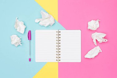Writer's block. Fikirler, beyin fırtınası, yaratıcılık, hayal gücü, son tarih, hayal kırıklığı kavramı. Ofis masası ile açık not defteri ve buruşuk Kağıt üzerine pastel arka plan boş sahte fotoğrafı üstten görünüm.