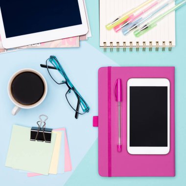 Kadınsı ofis büro çalışma alanı düz yatıyordu. Tablet ve smartphone, kahve, Not defteri ve kadın moda dergileri ile çalışma alanının üstten görünüm fotoğraf.