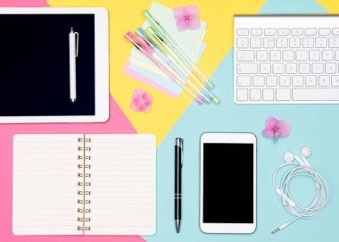 Ofis Masası çalışma alanı düz yatıyordu. Pastel arka plan üzerinde klavye, Not defteri ve kahve Kupası ile çalışma alanının üstten görünüm fotoğraf. Pastel renk çalışma Resepsiyon kavramı.