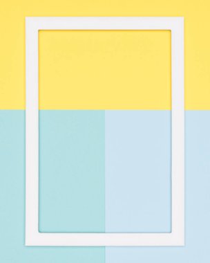 Soyut geometrik pastel mavi, yeşil ve sarı kağıt düz yatıyordu arka plan. Boş resim çerçevesini sahte kadar minimalizm, geometri ve simetri şablonuyla.