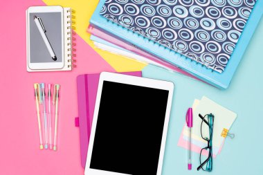Öğrenci resepsiyon alanı düz Lay çalışma. Üstten görünüm fotoğraf sahte tablet, klasörler ve pastel renkli arka plan üzerinde smartphone ile çalışma alanı. Pastel pembe, sarı ve mavi renk öğrenci çalışma masası.