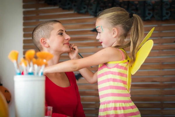 Cute Little Girl Applying Face Paint Her Mothers Face Halloween — Stock Photo, Image