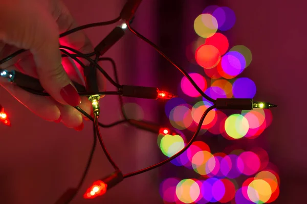 Kobiece Ręki Trzymającej Ciąg Christmas Lights Drzewa Xmas Rozmyte Tle — Zdjęcie stockowe