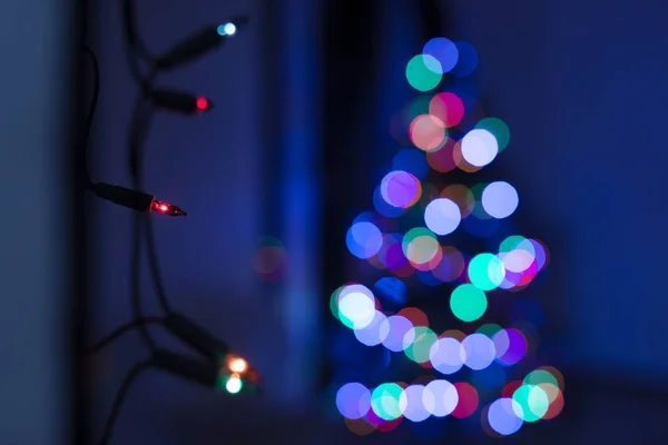 Cadena Luces Navidad Colgando Pared Con Árbol Navidad Desenfocado Fondo —  Fotos de Stock